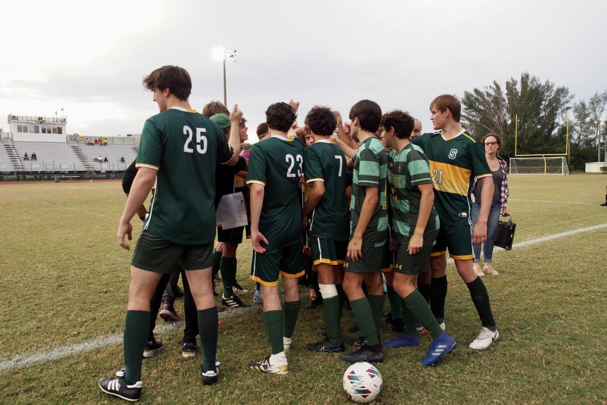The Shorecrest junior varsity soccer team, chock-full of three-sport athletes, gets together for inspirational words from Coach Casey McDonough before their game versus Clearwater Central Catholic High School.  Photo by Ellen Hommeyer.
