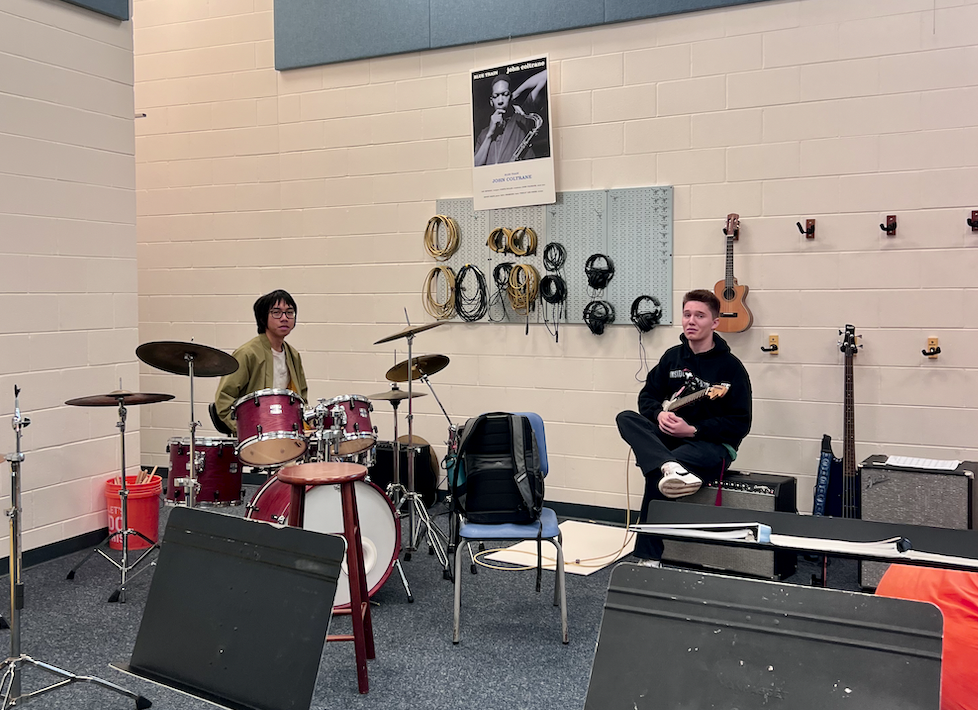 In the secluded Band Room, juniors Andrew Myint and Ethan Creadon strum out and drum out a community-time jam sesh for their band Very Real.