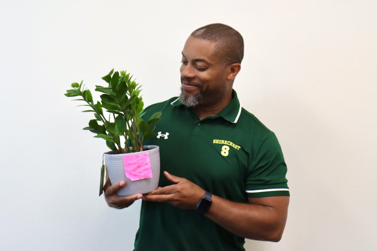 Upper School Health & Fitness Teacher Richard Cameron poses with one of his classroom plants, Beyoncé. He allows his students to name each one at the beginning of each school year.