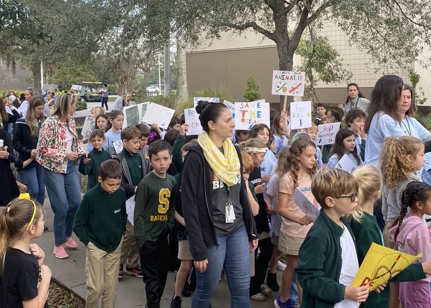 Students in third grade walk with teachers and parents outside Landy Hall in the march to conclude their Changemaker Unit. Students brought signs that called for change for matters personal to them. The march happened on January 19, 2024.