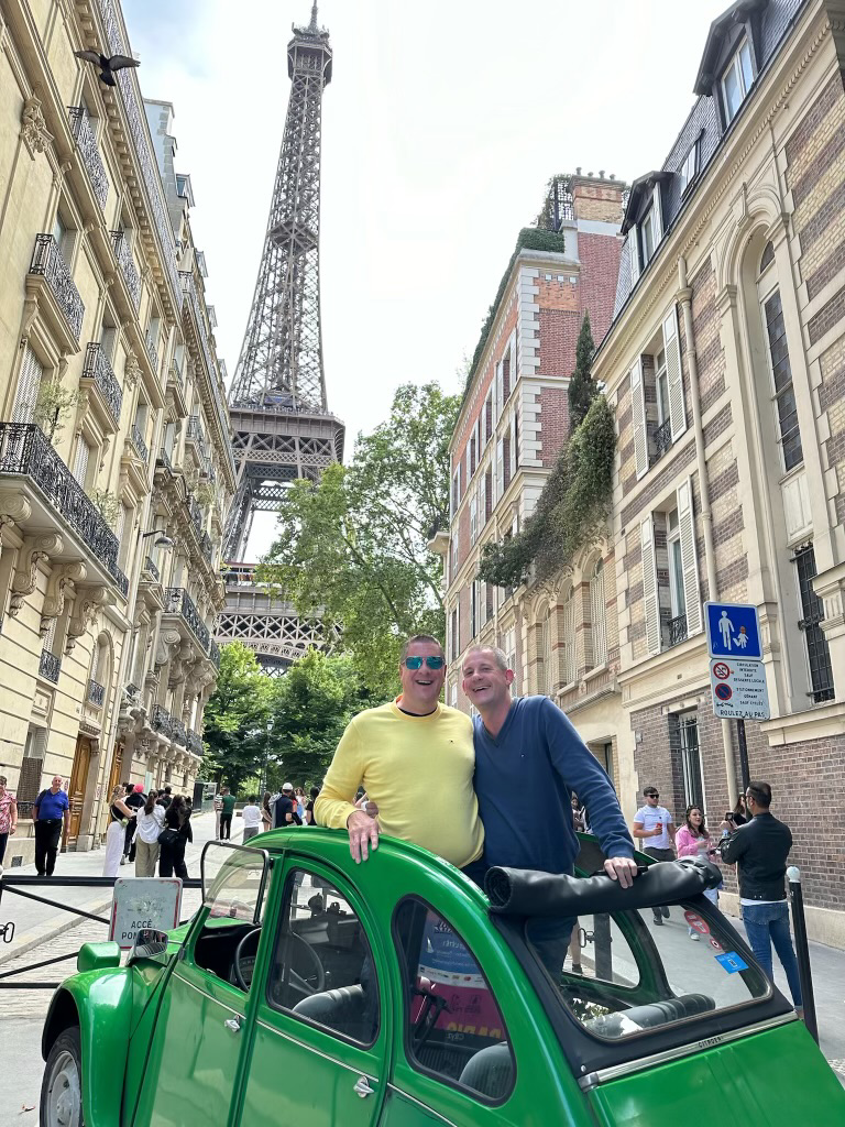 Al and his partner posing in Paris in front of the Eiffel Tower. Al has spent countless hours to support his curriculum, but also for enjoyment. Photo by a tour company.