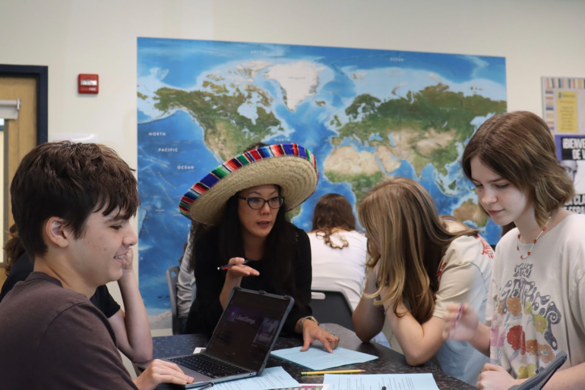 Shorecrest students (Left to right: junior Cooper Bullard, sophomore Ada Mollo, and sophomore Summer Farkas) write a song in Cove’s class about the difference between the words “ser” and “estar.”