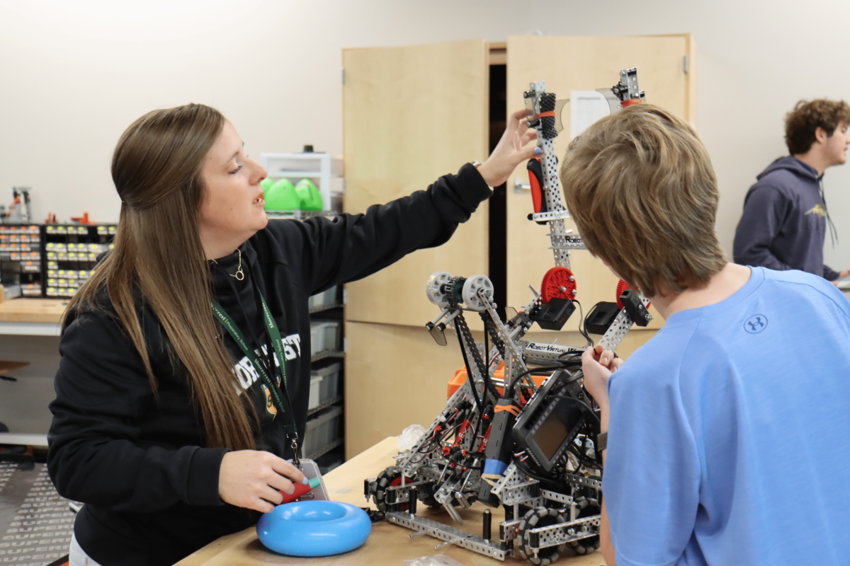 US STEM teacher Sarah Balisalisa assists Logan Sickling in the creation of his robotics team's robot. Balisalisa currently runs Shorecrest’s robotics program and teaches several computer science classes. This is her first year in these positions.  
