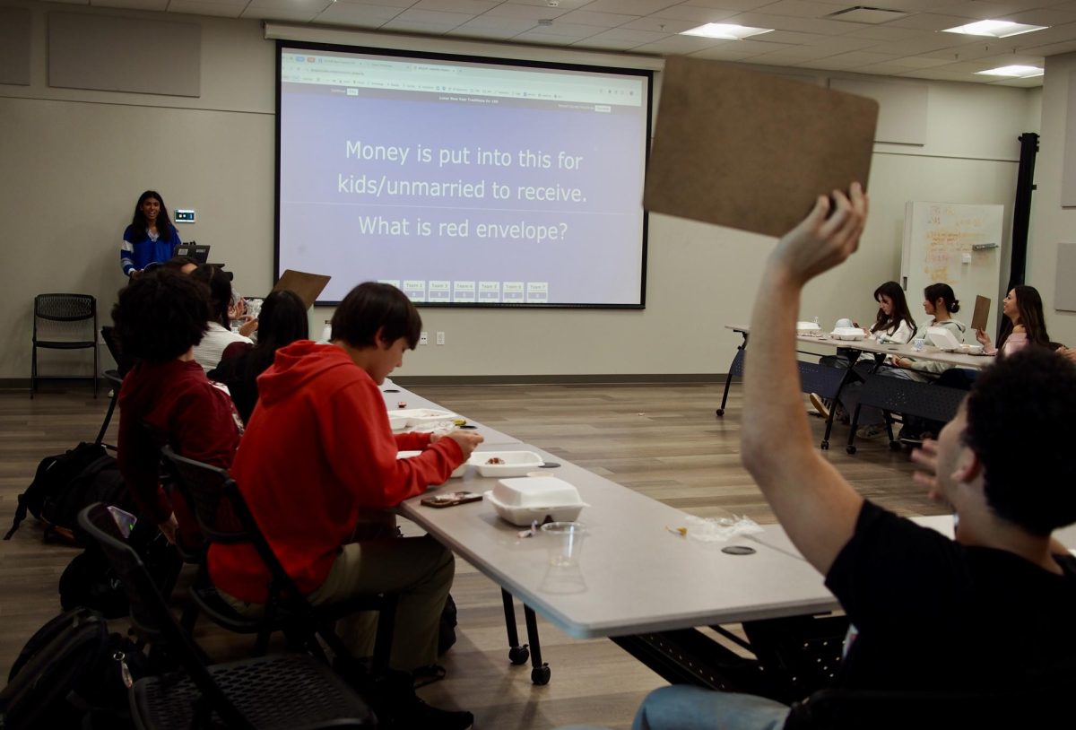 Junior Simi Damani leads the Asian Student Union (ASU) meeting during lunch. As the members engage in a game of jeopardy, senior Hayden Weaver holds up his whiteboard as he gets the correct answer. 