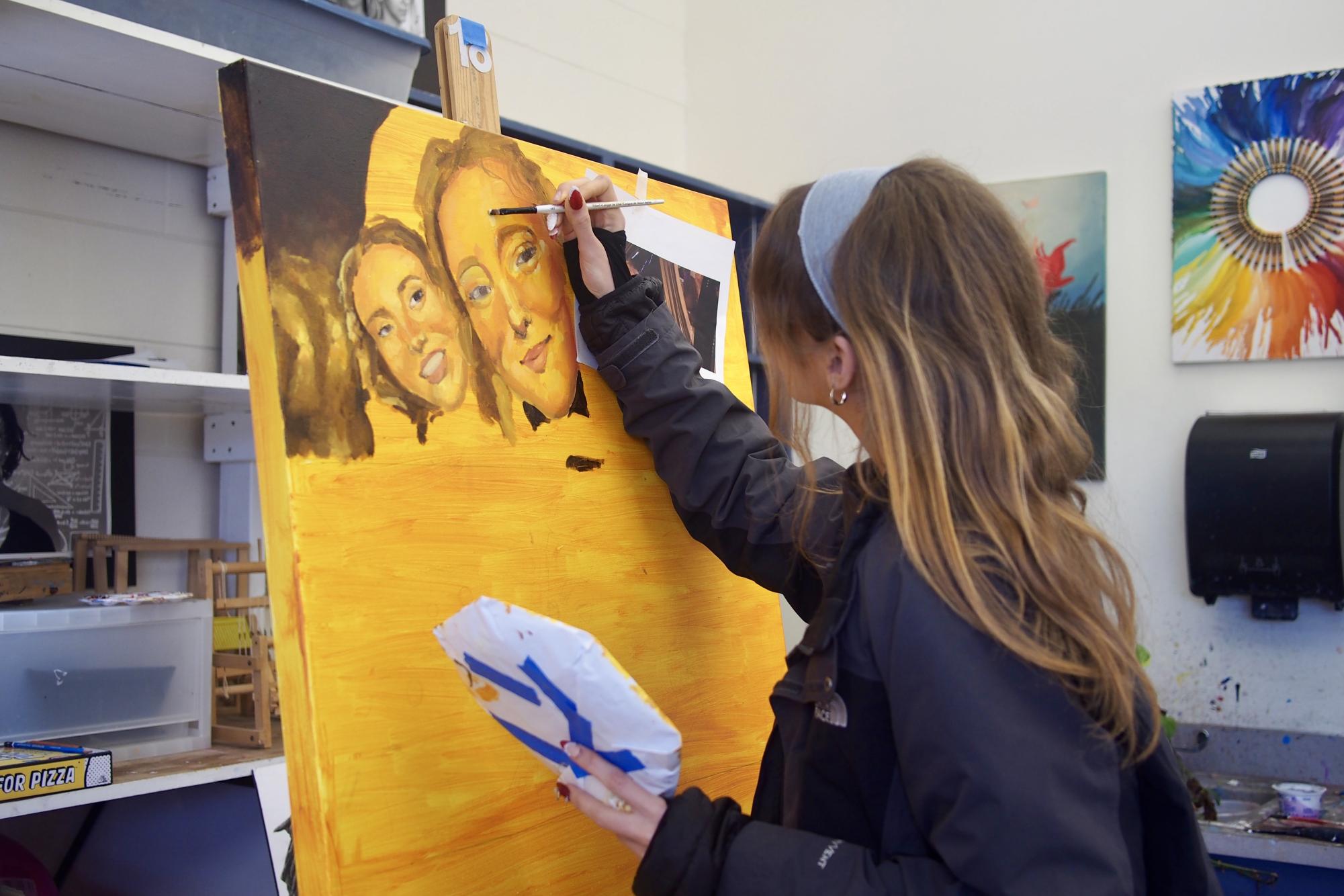 Junior Caroline Bean painting on a canvas in her studio art class. The class is led by Visual Arts Department Chair and US Arts & Humanities Teacher Charla Gaglio. 
