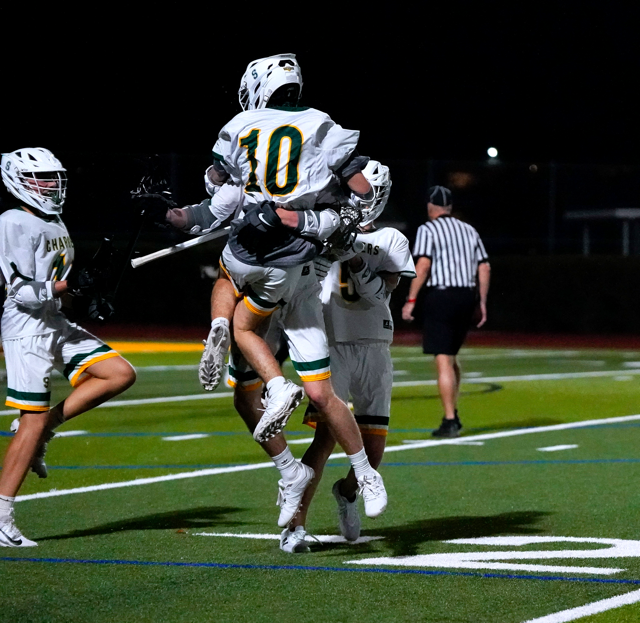 Senior Zev Schulman jumps into his teammate’s arms celebrating a goal during the JV boys lacrosse team’s game on February 13, 2025 vs. Boca Ciega High. Photo by Jocelyn Sheppard.