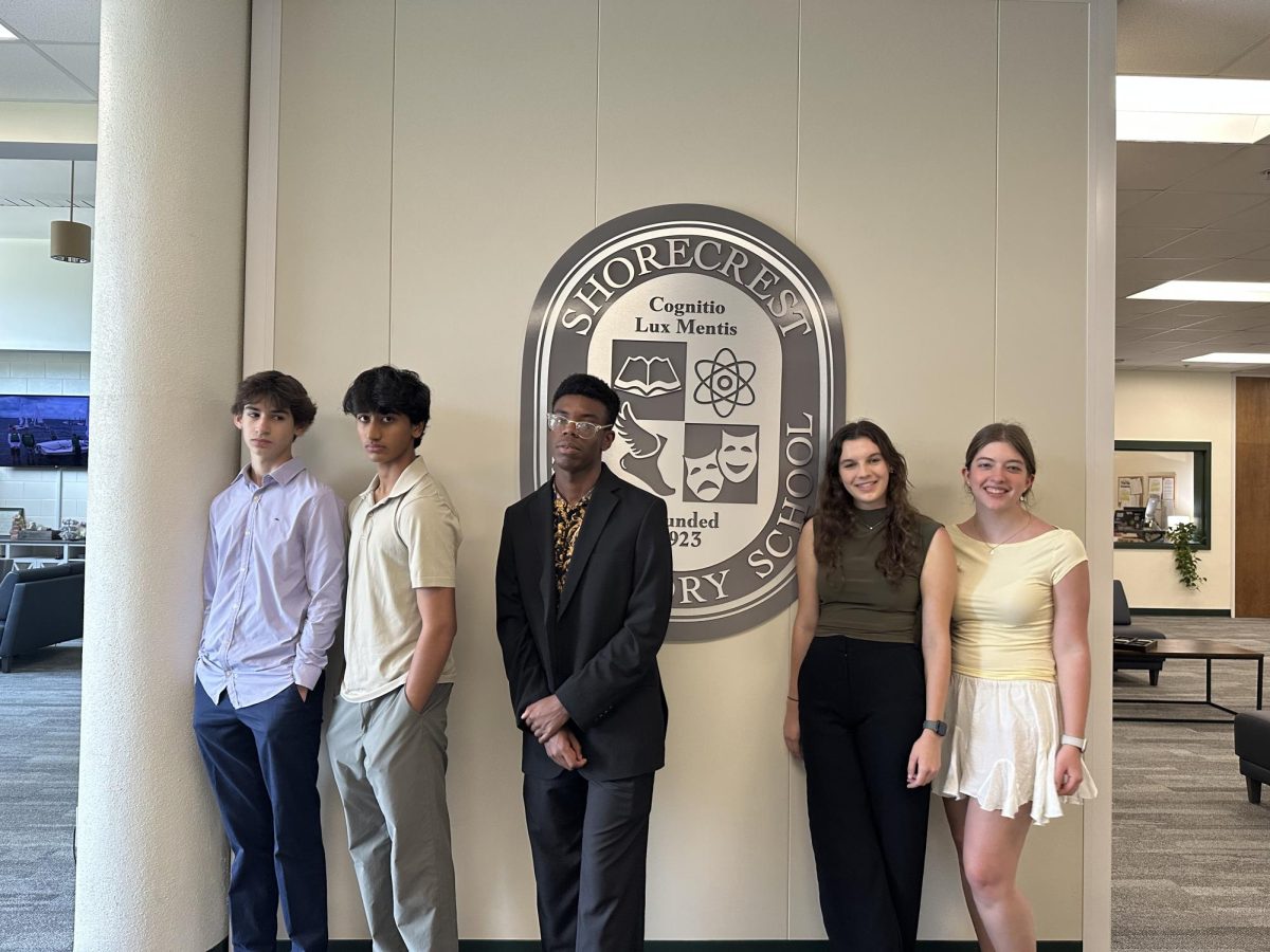 (Left to Right) Sophomores Ryan Jaffee and Aadi Pudur, and Juniors Caleb Williams, Leilani MacIntyre, and Alex Cirino, organizers of Career Day, pose in front of the Shorecrest emblem.
