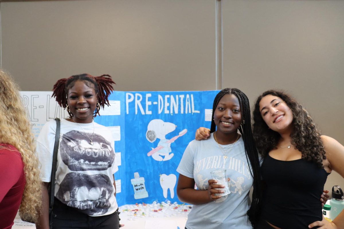 Senior Shanya Watson, junior Donyae Hazley and sophomore Natalia Davila smile in front of the Pre-Dental Club poster. The Pre-Dental Club was created by Hazley this year. 