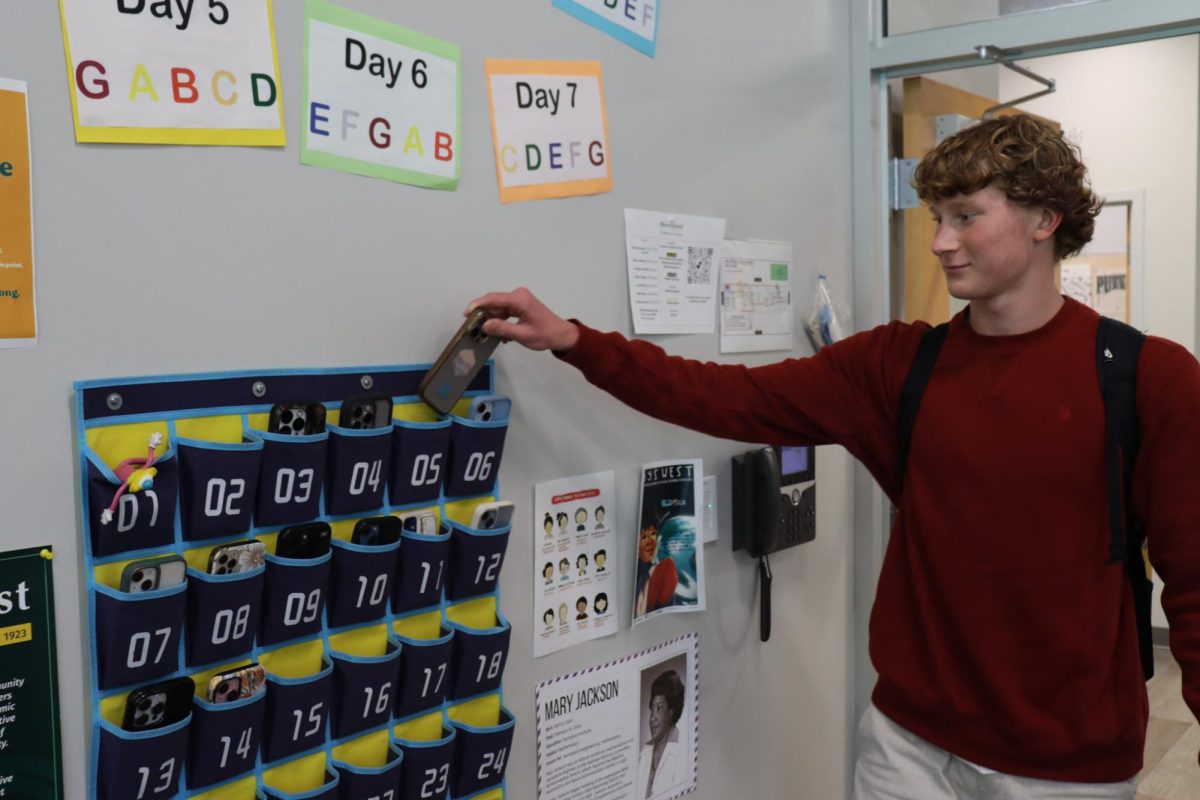 Junior Ryan Flugel puts his phone into the organizer before class in AP Calculus BC. All Shorecrest teachers this year are required to collect phones before class starts.