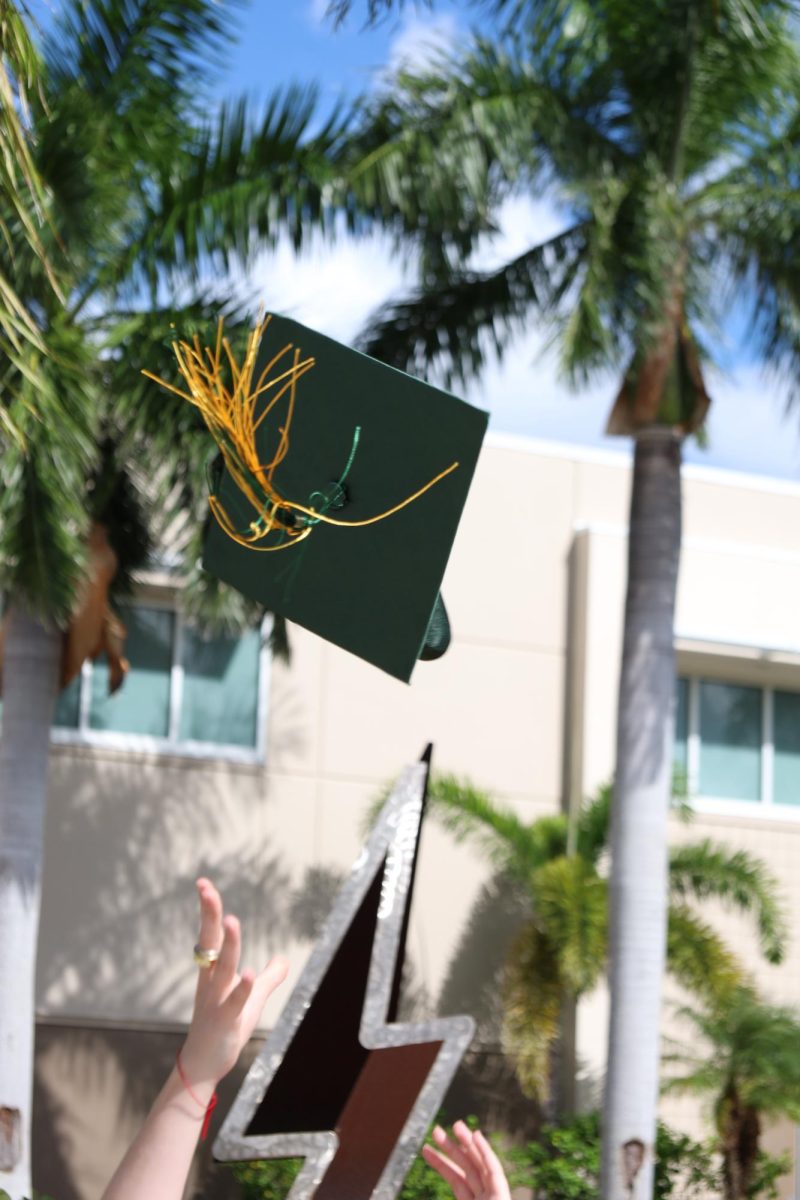 A Graduation Cap being tossed infront of Landy Hall. The tradition of tossing grad caps in the air started in 1912