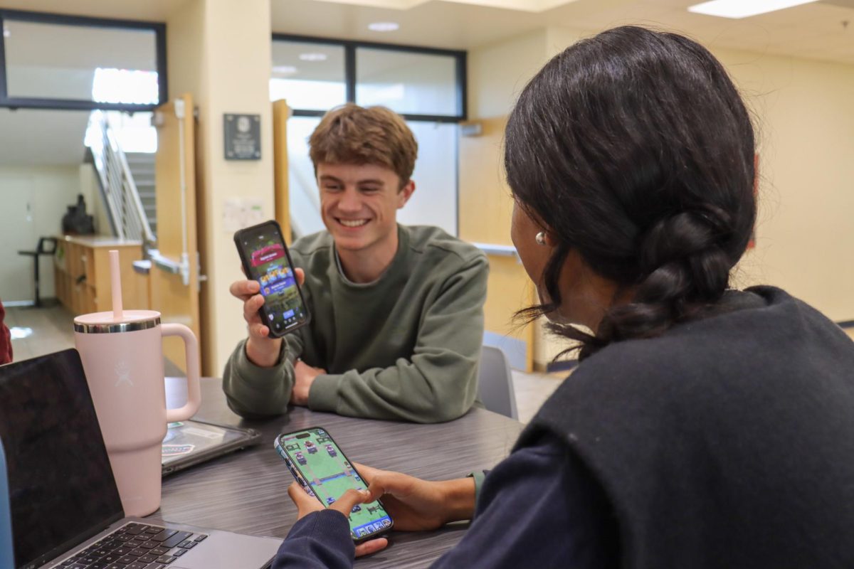 Senior Reece Campbell shows senior Simi Damani his newest accomplishment on Clash Royale. Recently, Clash has exploded in popularity among teenagers. 