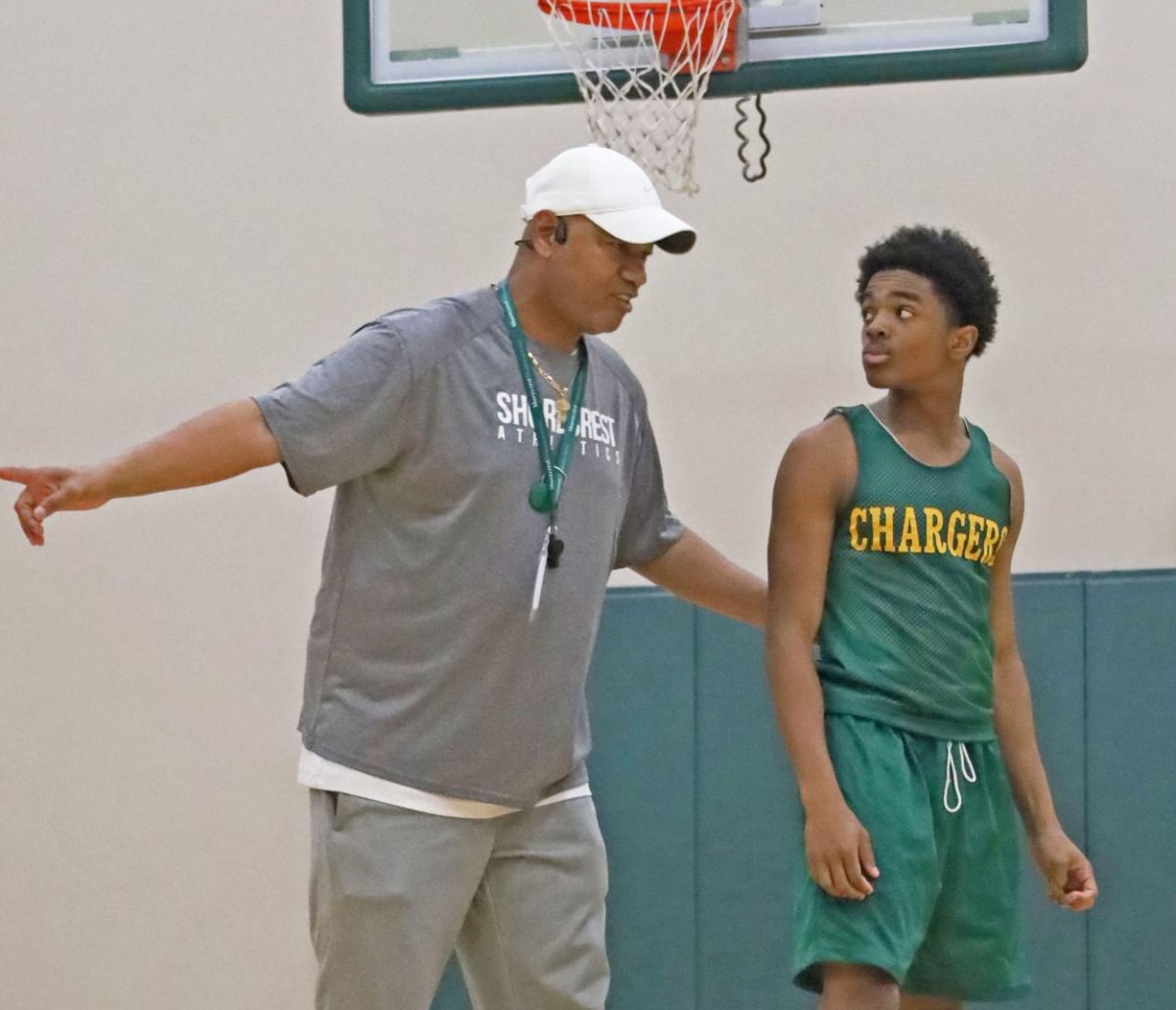 Varsity boys basketball head coach Allen Williams gives pointers to freshman Damir Hooker during practice. Hooker scored 18 points in a 85-23 win against Bayshore Christian on December 3. 