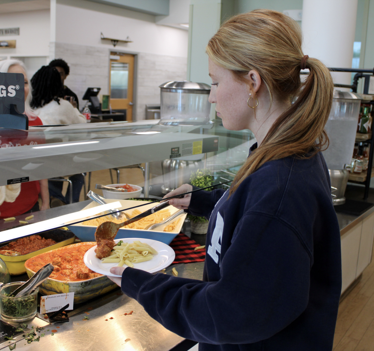 Senior Alex Lewis grabs meatballs from the Seasonings Bar in SAGE. Other protein offerings of the day included breakfast sausage and meat sauce. 