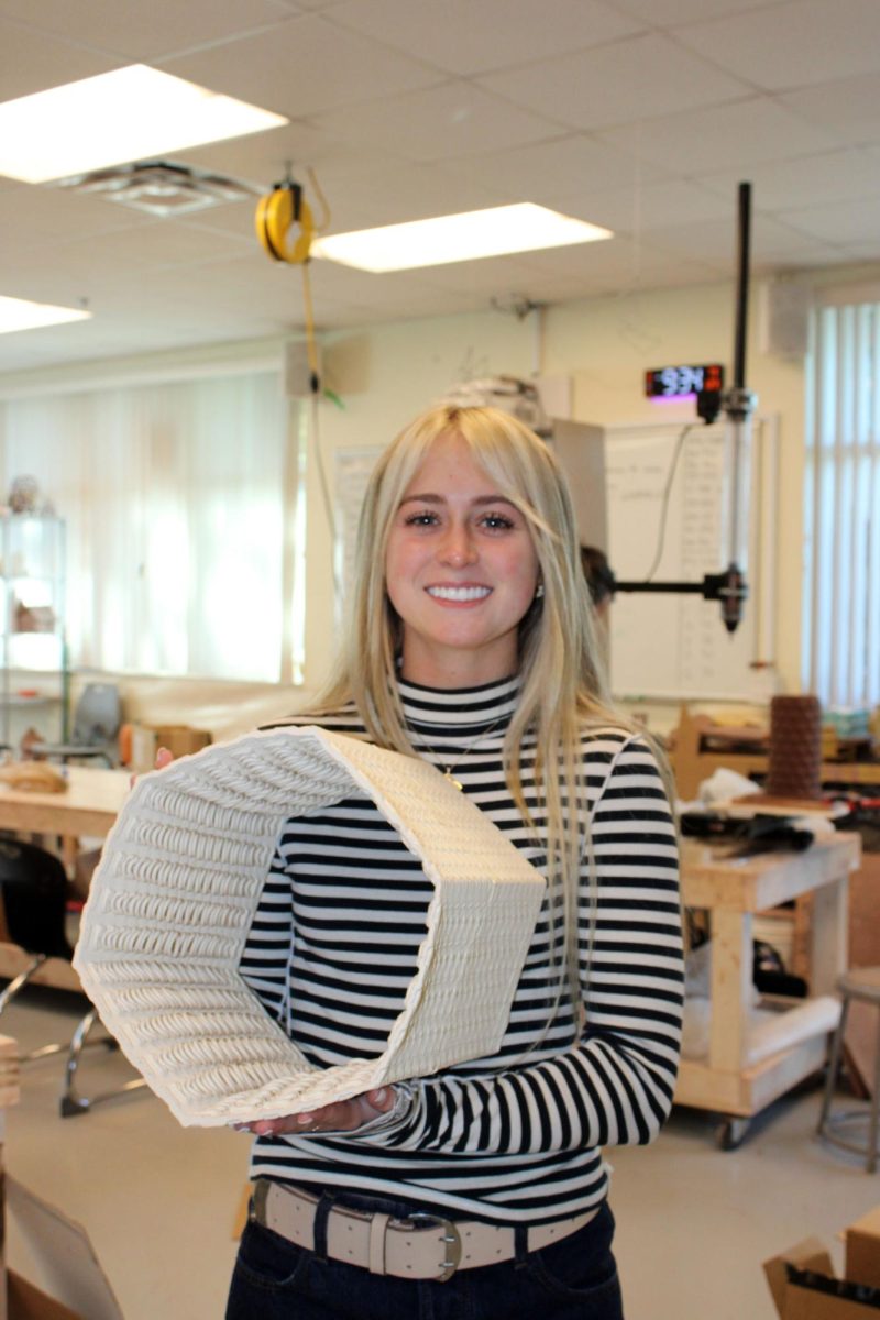 Junior Claire James holds a 3D printed, model oyster reef. James is President of the Fishing Club.