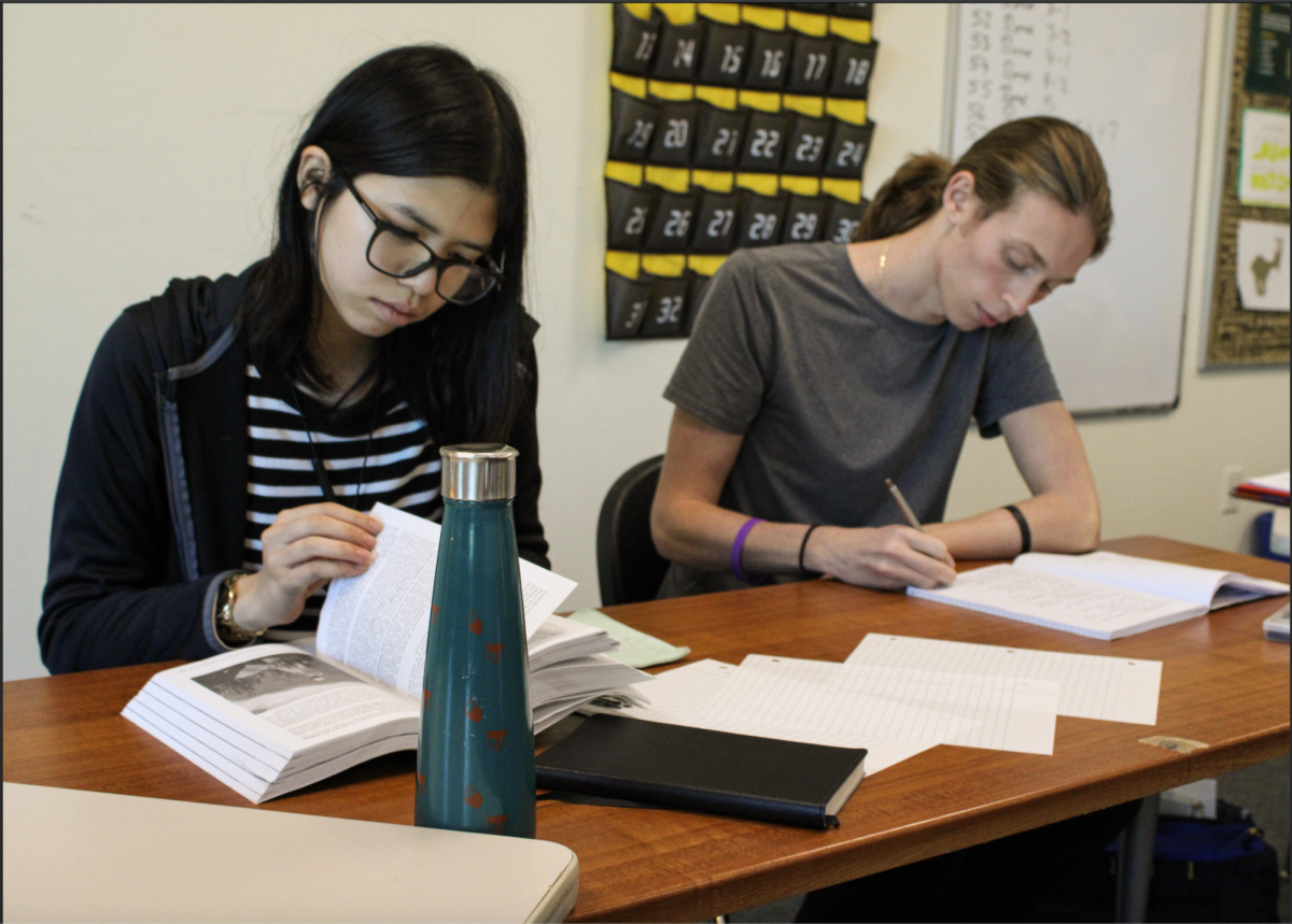 Sophomore Kiera Nguyen-Lim and Junior Tyler Biggar handwrite an assignment for their history classes. Some teachers are now requiring students to handwrite essays following use of AI.