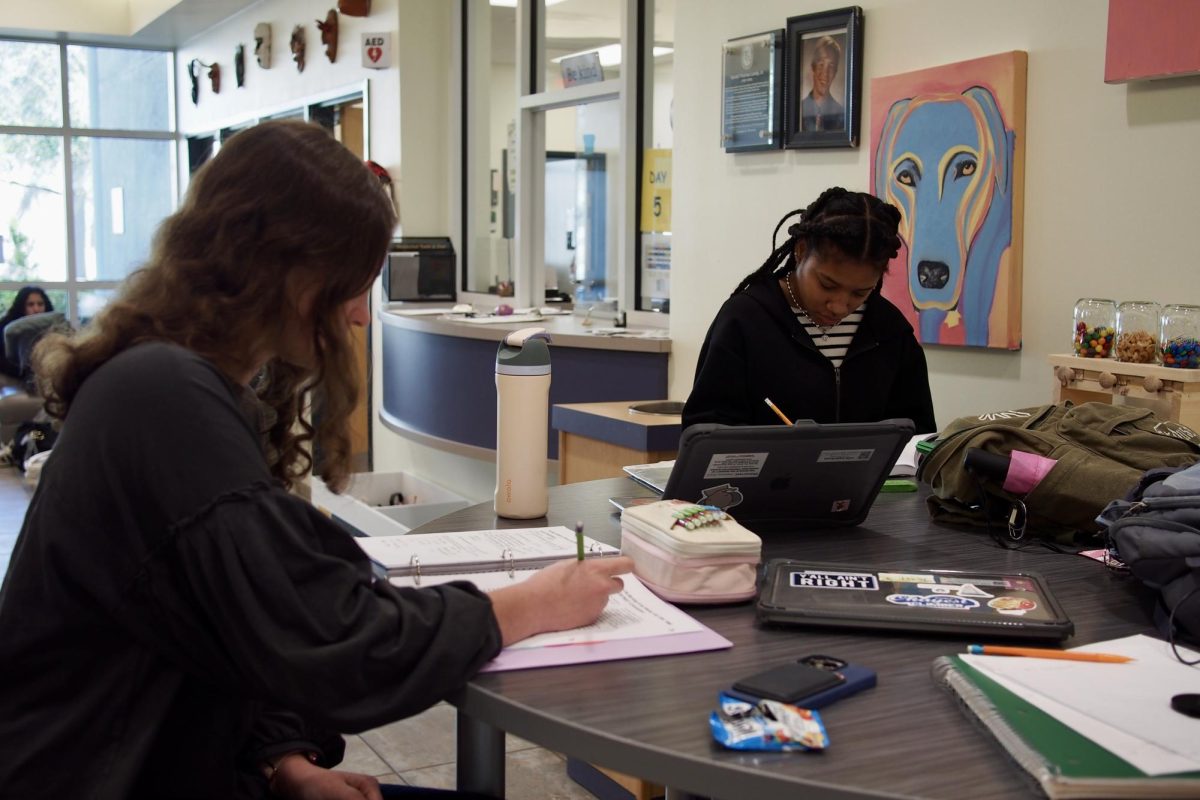 Two seniors work on their homework assignments at the Senior tables in Landy Hall.
