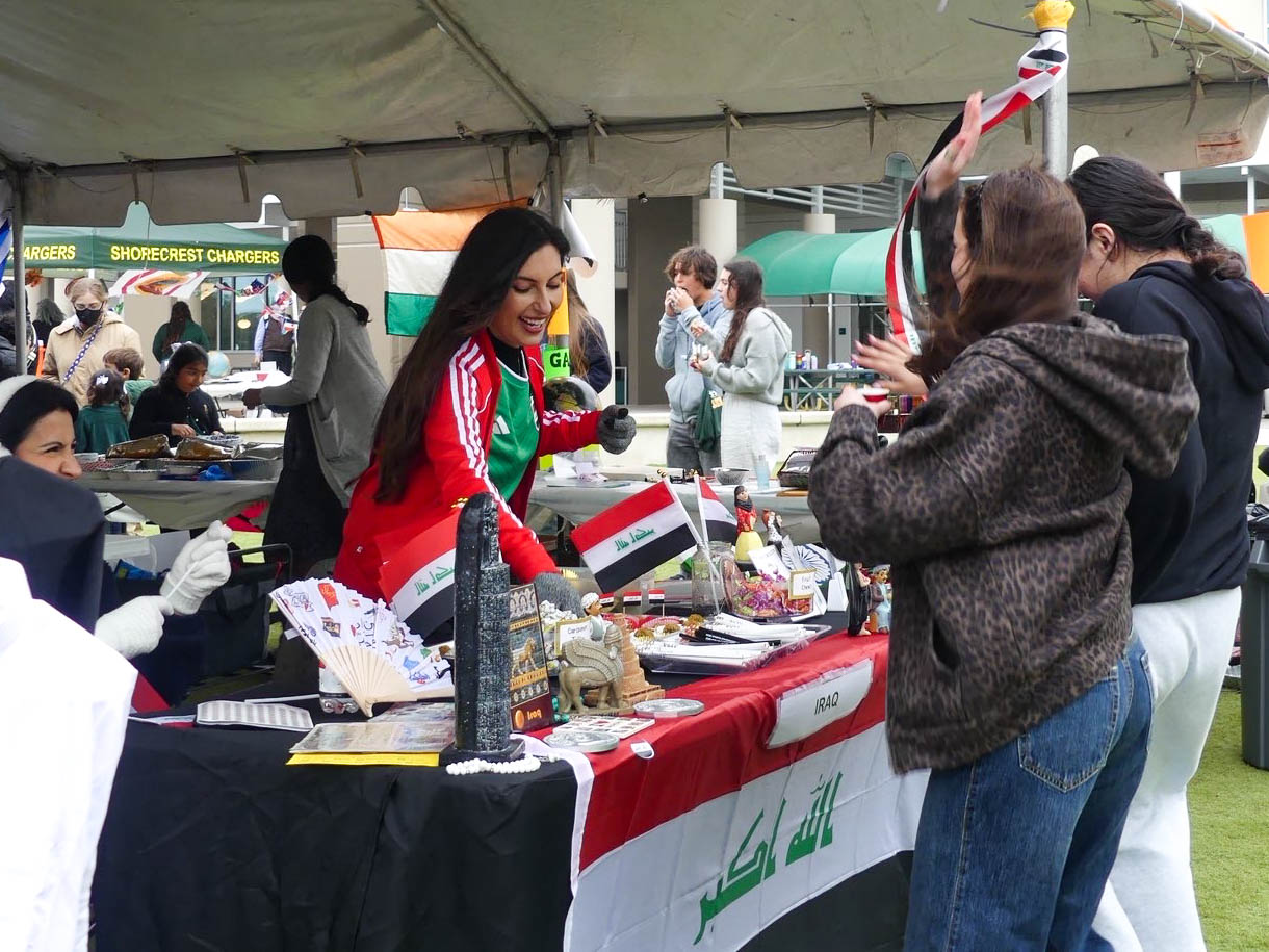 A parent volunteer teaches students about Iraq at her booth.